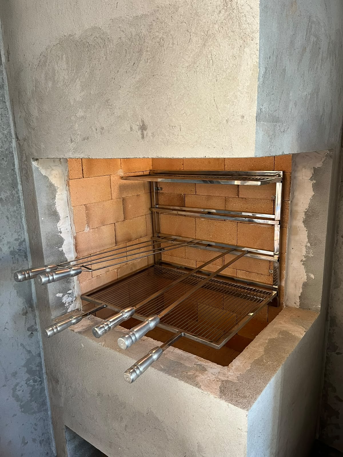 Churrasqueira de obra em tijolo com acabamento de inox